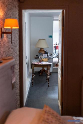 a hallway with a room with a table and a lamp at Le Val des Sens in Chatte