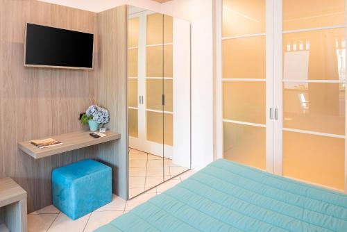 a small room with a bed and a tv at Blue Lake Residence - Bardolino in Bardolino
