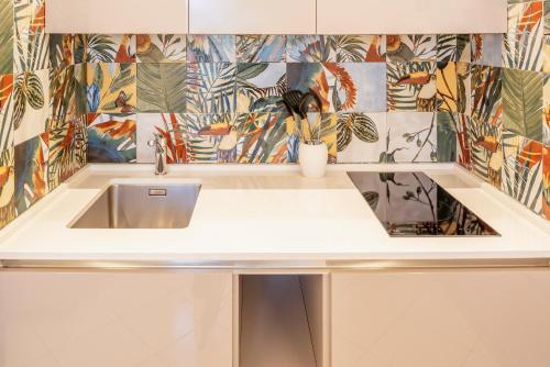a kitchen with a sink and a tile wall at Blue Lake Residence - Bardolino in Bardolino