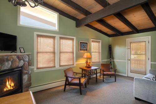 a living room with a fireplace and a tv at Whitneys Inn at Black Mountain in Jackson