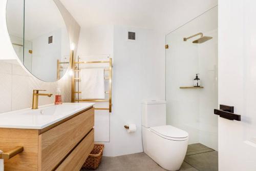 a bathroom with a sink toilet and a mirror at KozyGuru Sydney CBD Harbor View Loft with Parking in Sydney