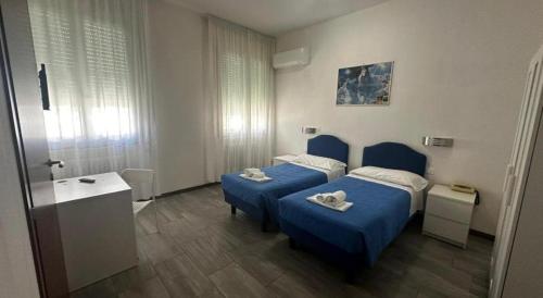 a hotel room with two beds and a bathroom at Hotel Franca in Riolo Terme