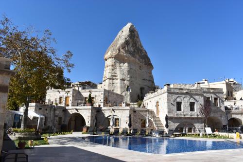 an old building with a swimming pool in front of it at Göreme Cave Suites in Goreme