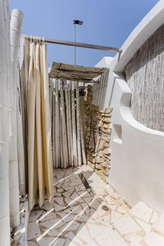 a white building with curtains on the side of it at Port 5 min-Close to Beach Summer Design Wi-Fi in Ischia