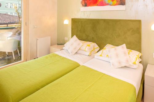 a bedroom with a green and white bed with pillows at Blue Lake Residence - Bardolino in Bardolino