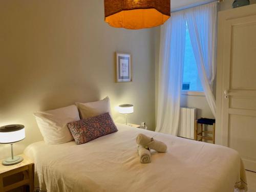 a stuffed teddy bear sitting on top of a bed at Le Joyeux - T3 au coeur du Quartier Haut in Sète