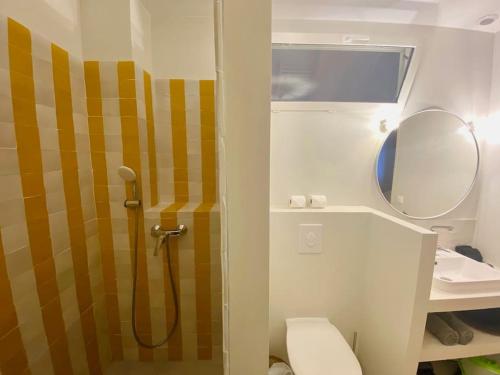 a bathroom with a shower with a toilet and a mirror at Le Joyeux - T3 au coeur du Quartier Haut in Sète