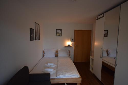 a small bedroom with a bed with white sheets at Nestwerk Komfort R23-13 - Balkon, Arbeitsplatz & Hochschulnähe in Biberach an der Riß