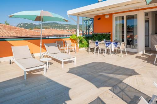 a patio with chairs and tables and an umbrella at Blue Lake Residence - Bardolino in Bardolino