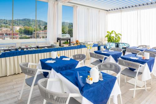 a restaurant with blue and white tables and chairs at Blue Lake Residence - Bardolino in Bardolino