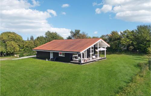 a small house with a large grass yard at Three-Bedroom Holiday Home In Askeby in Askeby