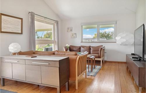 a living room with a couch and a tv at Three-Bedroom Holiday Home In Askeby in Askeby