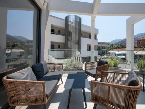 a balcony with chairs and a couch and a table at Mare Village Hotel in Georgioupolis