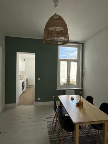 une salle à manger avec une table et une fenêtre dans l'établissement Maison plein cœur de Malo-les-Bains - Proximité plage et commerces, à Dunkerque