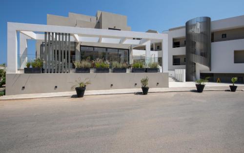 a large white building with potted plants on it at Mare Village Hotel in Georgioupolis