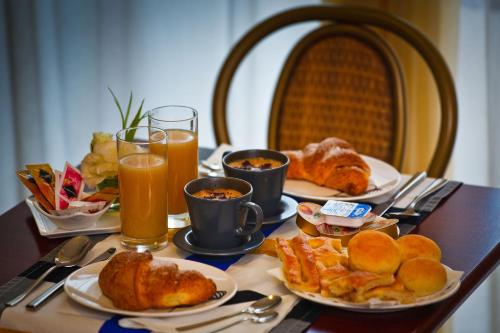 a table with plates of breakfast foods and drinks at Hotel Boccascena in Genoa