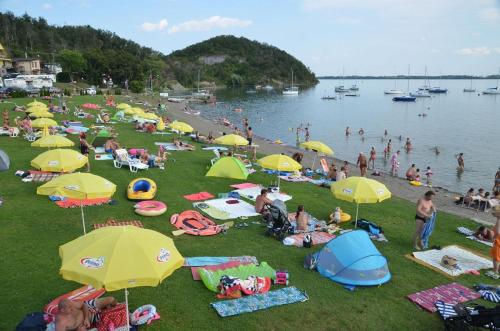a large group of people on a beach with umbrellas at Dovolenkový dom Nika in Vinné