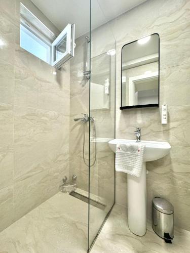 a bathroom with a sink and a glass shower at Apartmani Terminal in Budva