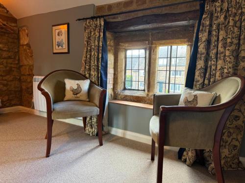 a room with two chairs and a window at The Royal Oak in Eydon