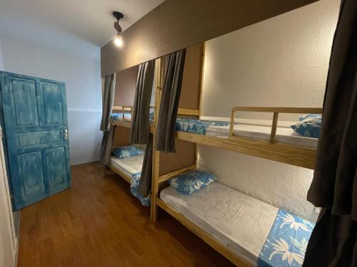a room with three bunk beds and a door at HOSTEL ARACAJU Sequência Surf Paradise POUSADA in Aracaju