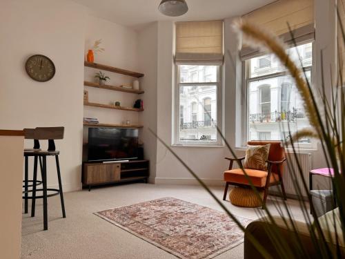 a living room with a television and a chair at Quaint apartment in Central Brighton - Sleeps 2 to 6 in Brighton & Hove