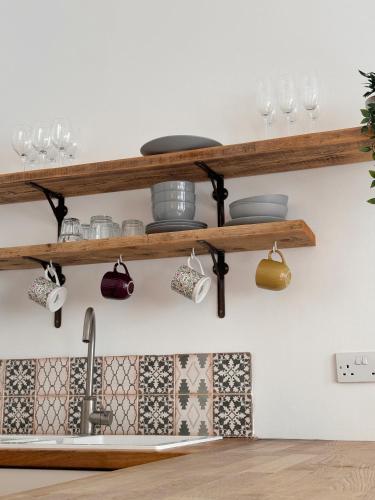 a shelf above a kitchen sink with pots and pans at Quaint apartment in Central Brighton - Sleeps 2 to 6 in Brighton & Hove