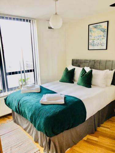 a large bed in a room with a large window at 20 minute to central London beautiful apartment in London