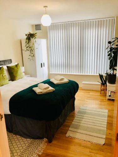 a bedroom with a large bed with two towels on it at 20 minute to central London beautiful apartment in London