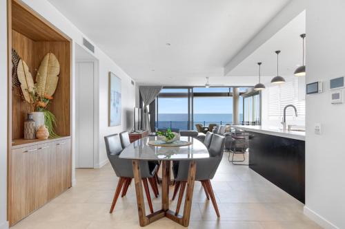 a kitchen and dining room with a table and chairs at Bokarina Beach Apartments, an Ascend Collection Hotel in Bokarina