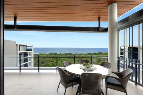 a dining room with a view of the ocean at Bokarina Beach Apartments, an Ascend Collection Hotel in Bokarina