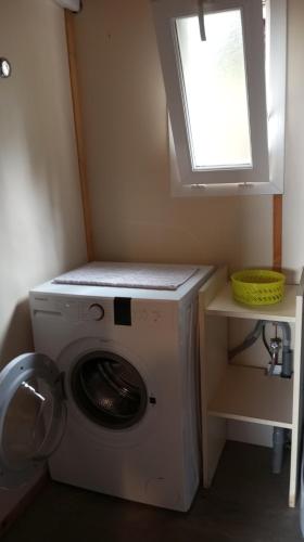 - un lave-linge dans une petite pièce avec fenêtre dans l'établissement Chalet familial entre les pins, à Agde