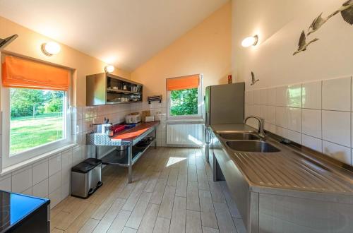 JabelにあるWildgans - Stilvolles Ferienhaus mit Terrasse, Seeblick & Naturidylle am Loppiner Seeのシンクとカウンタートップのあるキッチン