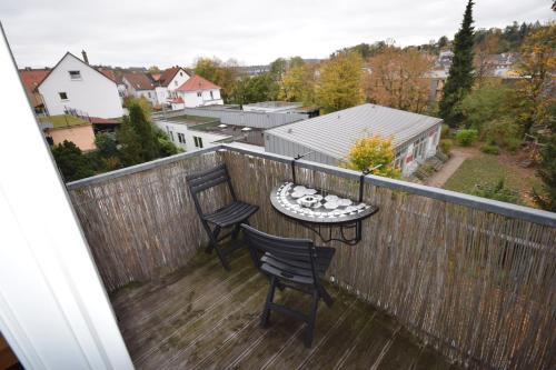 a balcony with two chairs and a table on a fence at Nestwerk Komfort R23-12 - Balkon, Arbeitsplatz & Zentrumsnah in Biberach an der Riß