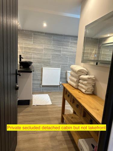 a bathroom with a stack of towels on a table at TheWaterfrontLodges in Coventry