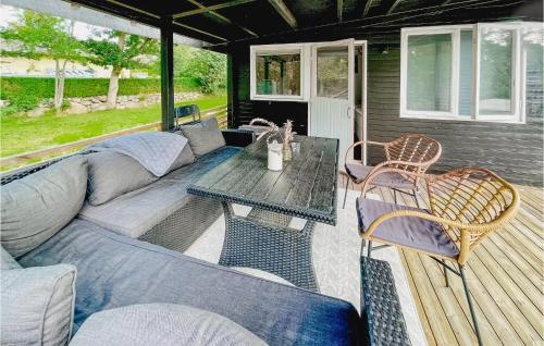 a living room with a couch and a table on a deck at 1 Bedroom Awesome Home In Ronneby in Ronneby