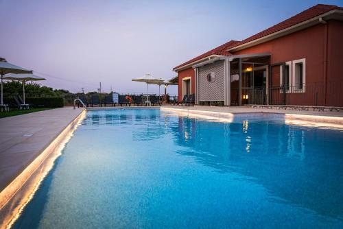 a large blue swimming pool next to a house at Crystal Palace - Vista in Skala Kefalonias