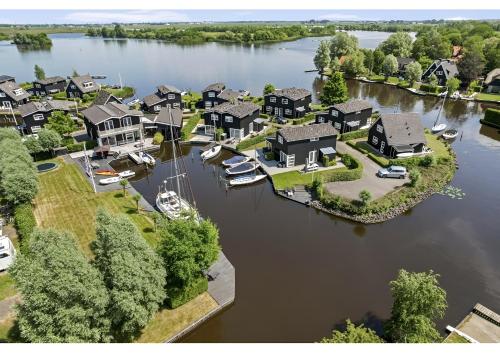 an aerial view of a home on a lake at Waterpark Oan 'e Poel bij Sneekermeer in Terherne