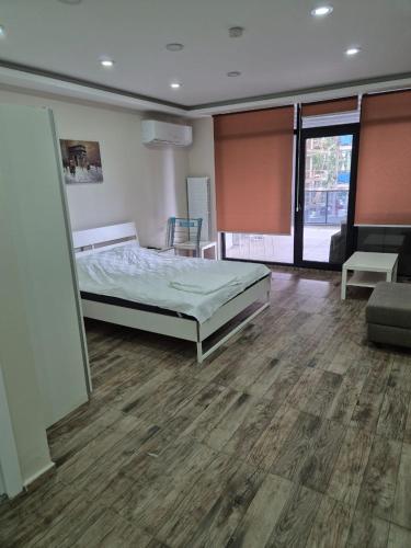 a bedroom with a bed in a room with a wooden floor at Gardi Apart Hotel in Batumi