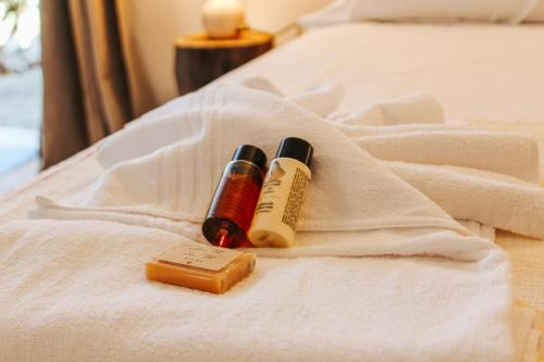 two bottles of essential oils sitting on a bed at Penedo Escape Nature in Colares