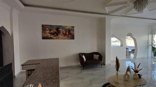 a living room with a painting on the wall at Taj Al Arab Hotel Al Burimi in Al Buraymī