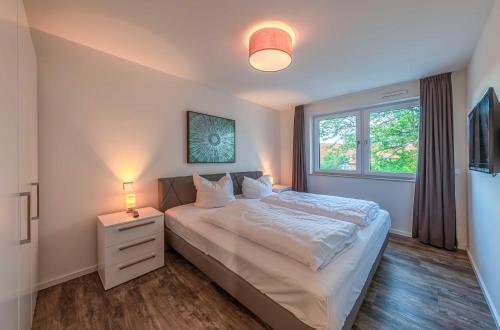 a bedroom with a large bed and a window at Hafenflair- Apartment mit Balkon & Kamin in der Hafenresidenz in Waren