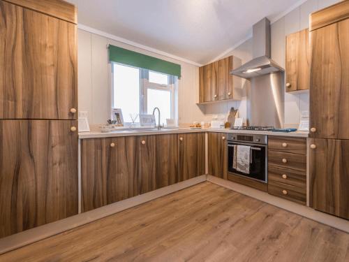 a kitchen with wooden cabinets and a stove top oven at Glen Lodge in Birnam