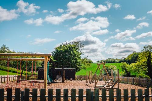 a playground with a swing set in a park at Ivy Caravan 2 at Thurston Manor Leisure Park in Dunbar