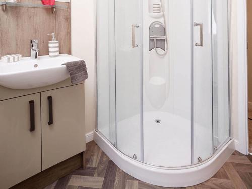 a bathroom with a shower and a sink at Limetree Lodge 2 at Thurston Manor Leisure Park in Dunbar