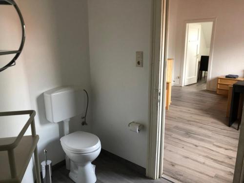 a white bathroom with a toilet and a hallway at Monteurwohnungen in Andervene in Andervenne Oberdorf