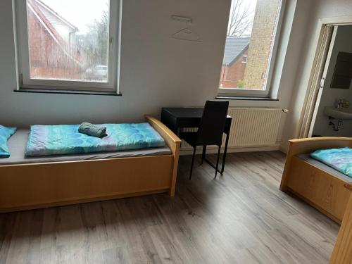 a room with two beds and a desk and a table at Monteurwohnungen in Andervene in Andervenne Oberdorf