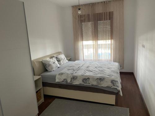 a small bedroom with a bed and a window at Apartman City Kvart Podgorica lux in Podgorica