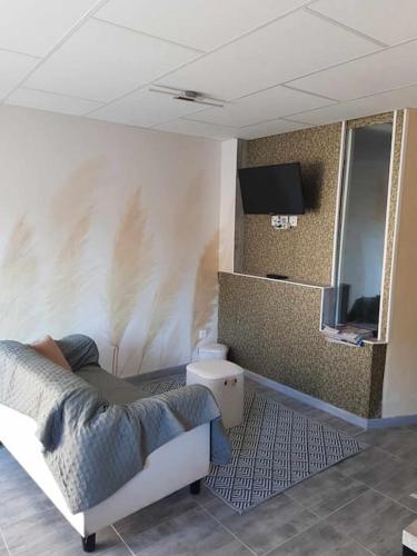 une personne assise sur un lit dans une pièce dans l'établissement appartement 2-4 personnes, à Hargarten-aux-Mines