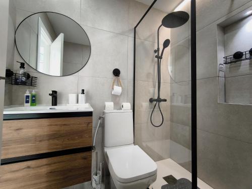 un bagno con doccia, WC e specchio di Panorama Golf, Villa Martn semi-detached duplex a Villacosta