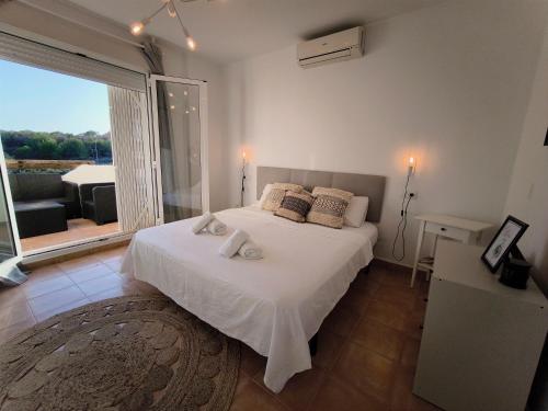 una camera da letto con un letto bianco con una grande finestra di Panorama Golf, Villa Martn semi-detached duplex a Villacosta
